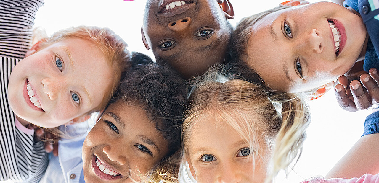 Lachende Kinder unterschiedlicher Hautfarbe.