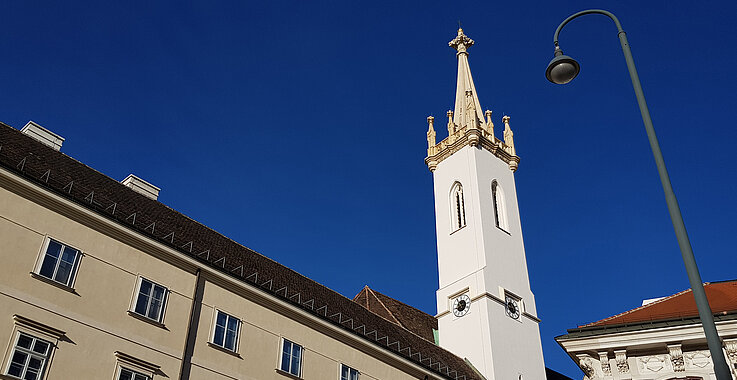 Der weithin sichtbare Kirchturm von Sankt Augustin, im Schatten der Wiener Hofburg.