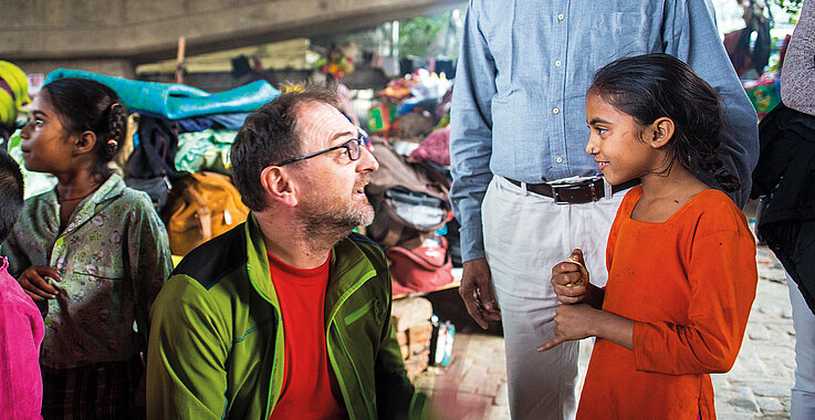 Reinhard Heiserer spricht mit einem Mädchen in Neu-Delhi.