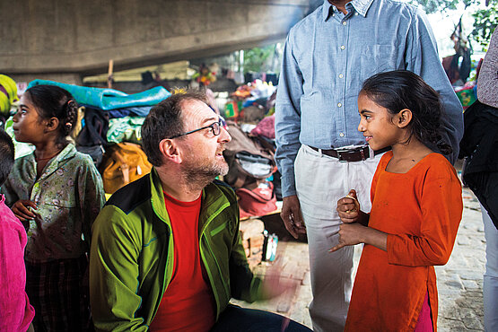 Reinhard Heiserer spricht mit einem Mädchen in Neu-Delhi.