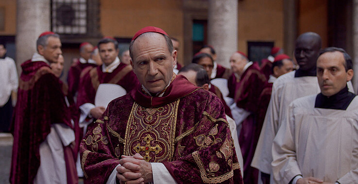 Ralph Fiennes mimt Kardinal Lawrence, der dem Konklave als Leiter vorsteht und so manche Krise durchstehen muss.