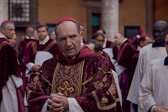 Ralph Fiennes mimt Kardinal Lawrence, der dem Konklave als Leiter vorsteht und so manche Krise durchstehen muss.